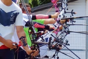 Photo des bras de tous les archers tenant leurs arcs de toutes les couleurs.